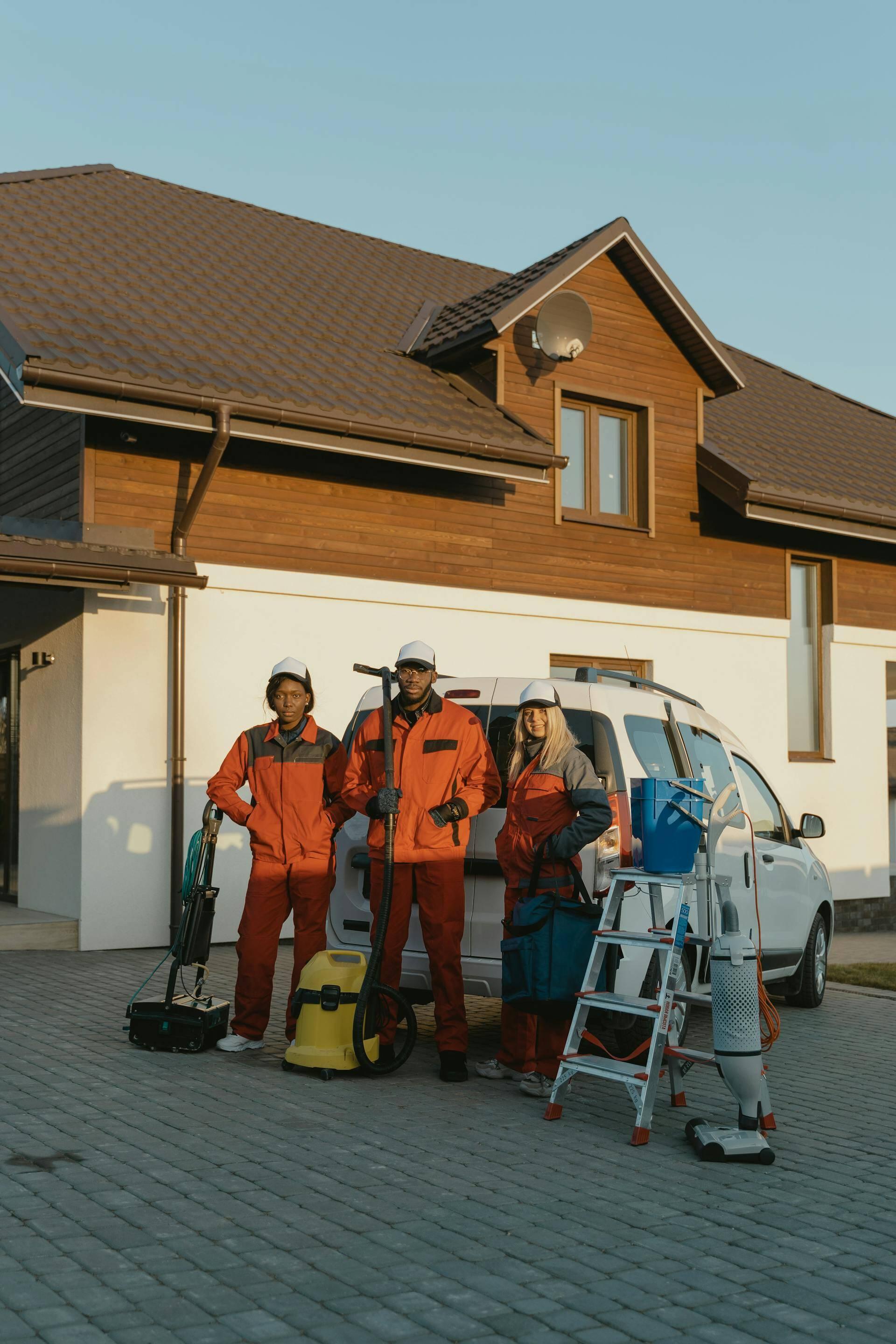 Grime Reapers cleaners in orange workwear beside their van