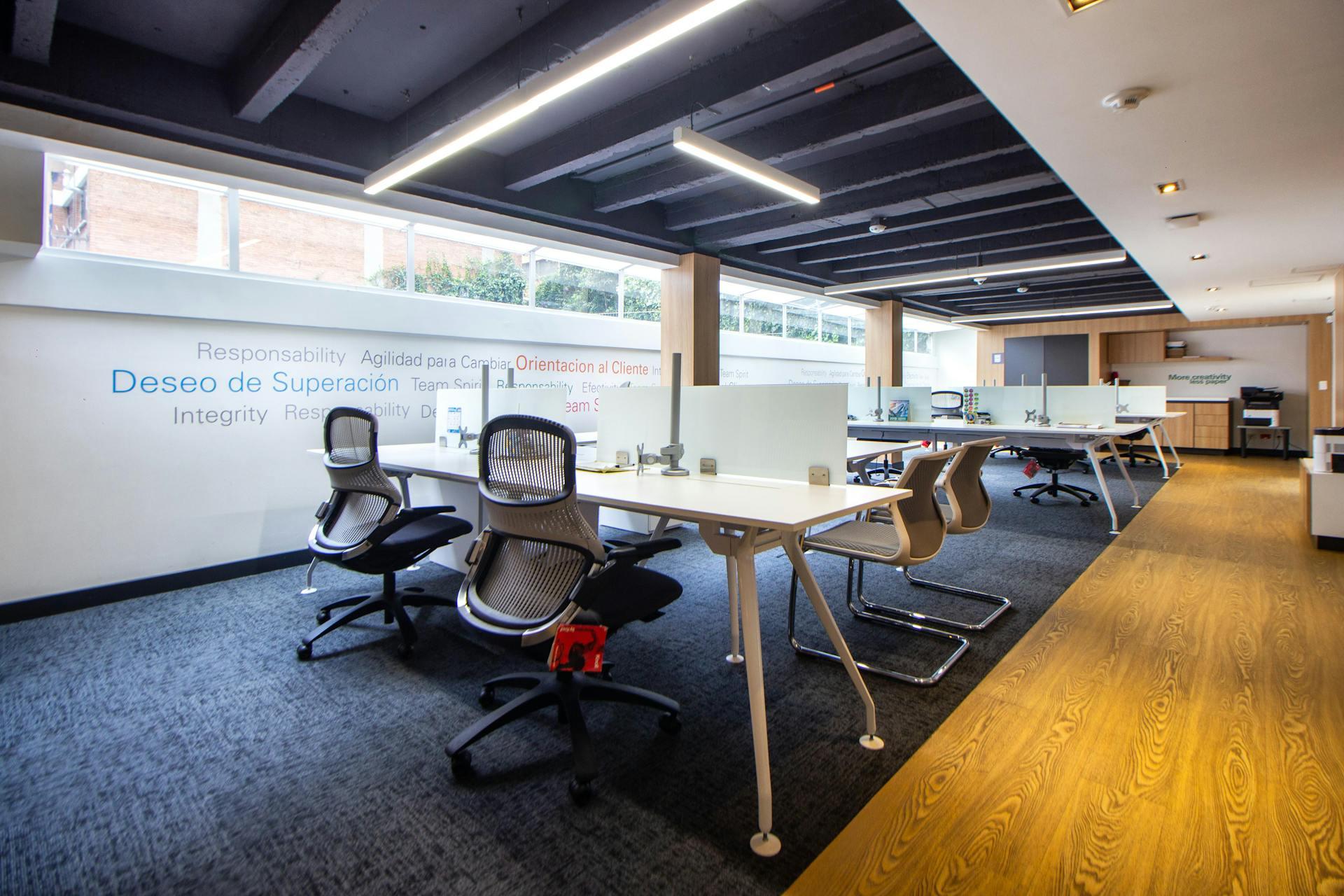 An open-plan office floor with carpet tiles and a timber walkway